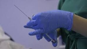 Inxección en mans dun médico